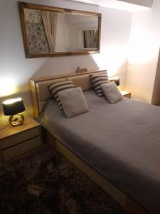 a bedroom with a bed with a mirror on the wall at River Lux in Bacău