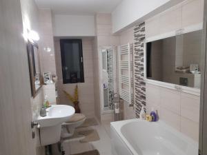 a bathroom with a sink and a tub and a toilet at River Lux in Bacău +12 photos