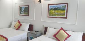 a room with two beds and a painting on the wall at Tam Cốc Anna Thắm Hotel in Ninh Binh