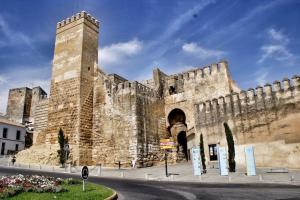 a large stone building with an entrance to a castle at Duplex Santamaria in Carmona