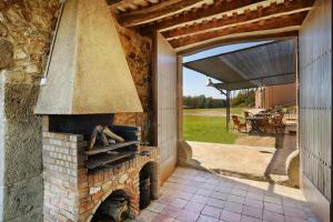 an outdoor brick oven with a patio in the background at El Mas Pla in Caldes de Malavella