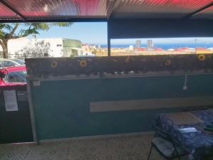 Zimmer mit einer blauen Wand, einer Bank und einem Fenster in der Unterkunft Guest Room Santa Cruz in Santa Cruz de Tenerife