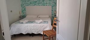 a small bedroom with a bed and a wooden chair at Hotel Canarco in Viareggio