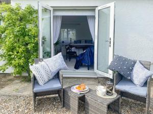 a patio with two chairs and a table with a plate of food at Wisteria Lodge At The Shipon in llanbedr-dyffryn-clwyd