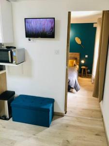 a room with a bed and a television on a wall at Bleu Lavande 1 - Appartement cosy ambiance village in Istres