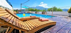 un banco de madera sentado junto a una piscina en Throne Villa Kambia with heated pool, en Klis