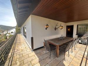 a patio with a wooden table and chairs on a deck at Private Spacious Villa near Winterberg and Willingen 14 Guests HUGE GARDEN Free Parking for Multiple Cars in Olsberg