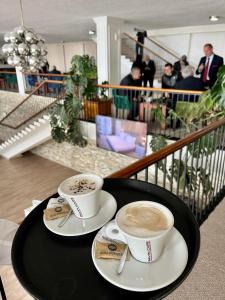 two cups of coffee sitting on a black table at Hotel Villa Garden Ulcinj-Ulqin in Ulcinj