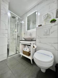 een witte badkamer met een toilet en een wastafel bij Hotel Villa Garden Ulcinj-Ulqin in Ulcinj