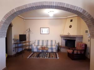 sala de estar con sofá y chimenea en Agriturismo Montemari, en Palaia