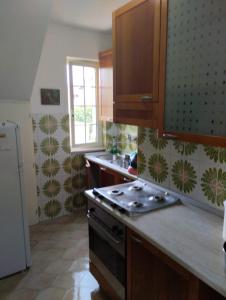 a kitchen with wooden cabinets and a stove top oven at Villa Lucia in Sabaudia
