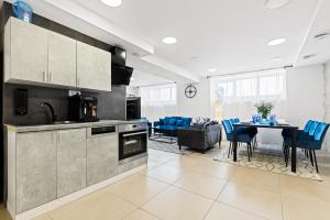 a kitchen and living room with a table and blue chairs at Sirena Apartment - Self check-in and free parking in Tallinn