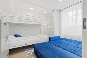 a bedroom with two beds and a blue couch at Sirena Apartment - Self check-in and free parking in Tallinn