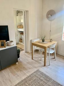 - un salon avec une table, des chaises et une télévision dans l'établissement Le Ptit Moulleau, à Arcachon