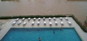 an overhead view of a swimming pool with chairs and water at Lisha The Grand Riverside Hotel in Vang Vieng