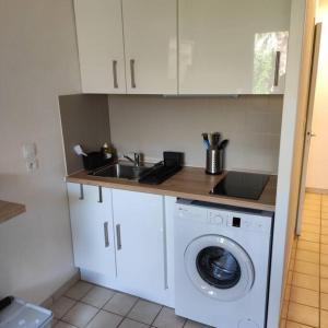 a kitchen with a washing machine and a sink at studio cabine quatre couchages classé 2 étoiles in Bormes-les-Mimosas