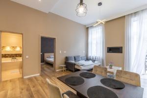 - un salon avec une table à manger et un canapé dans l'établissement Csengery Deluxe Home with Balcony, à Budapest