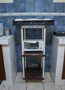 a microwave on a stand in a kitchen at Casa la Ermita in Antigua Guatemala