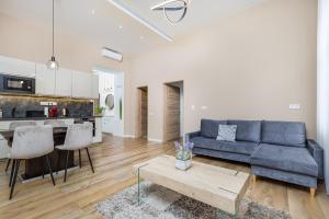 un salon avec un canapé bleu et une table dans l'établissement Csengery Deluxe Home with Balcony, à Budapest