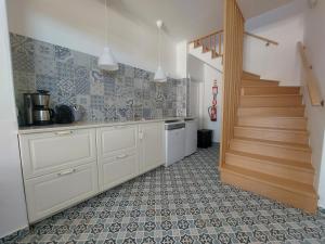 eine Küche mit weißen Schränken und einer Treppe in der Unterkunft Quinta RoSa - Almeirim in Almeirim