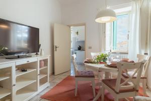 a living room with a television and a table with chairs at San Leonardo apartment in Lucca