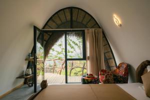 um quarto com uma porta aberta com uma cadeira e uma janela em Hippie Home em Mộc Châu