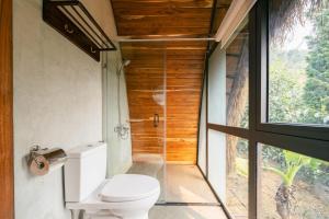 uma casa de banho com um WC e uma cabina de duche em vidro. em Hippie Home em Mộc Châu