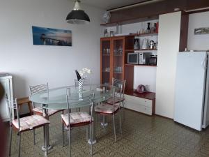een keuken met een tafel, stoelen en een koelkast bij Residence Spighetta 2 in Torri del Benaco
