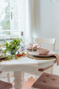 una mesa blanca con copas de vino y verduras. en San Leonardo apartment, en Lucca