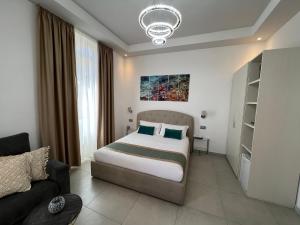 ein Schlafzimmer mit einem Bett und einem Sofa in der Unterkunft EVA affittacamere in La Spezia