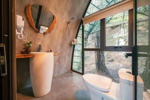 uma casa de banho com um WC, um lavatório e um espelho. em Hippie Home em Mộc Châu