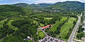 uma vista aérea de um parque de estacionamento com árvores e montanhas em Condo 304 33 Chemin du Hameau by Les Chalets Alpins em Stoneham