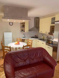 una cucina con tavolo e divano in pelle di Apartman Luka + FREE parking a Zara (Zadar)