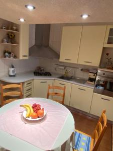 una cucina con tavolo e piatto di frutta di Apartman Luka + FREE parking a Zara (Zadar)