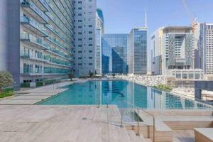 a swimming pool in a city with tall buildings at 5* Studio, 10min walk to Dubai Mall, 1min Bay Sqr in Dubai