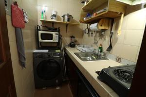 a small kitchen with a washing machine and a sink at Apartamento en La Candelaria - Centro Histórico in Bogotá