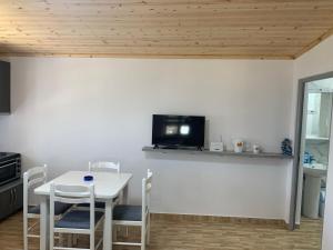 a kitchen with a table and a tv on a wall at Villas Ermali in Ksamil