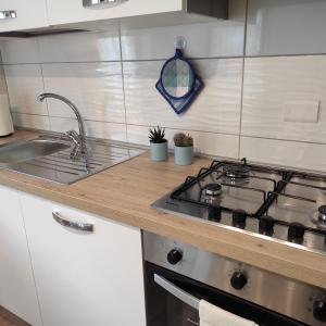 a kitchen with a stove top and a sink at Da Carla Dolomiti Val di Zoldo in Val di Zoldo