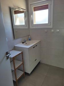 Baño blanco con lavabo y espejo en Casa Julio, bonita casa reformada con terraza y jardin privado, en Riezu