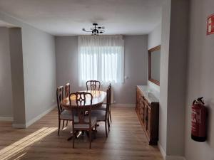 comedor con mesa, sillas y TV en Casa Julio, bonita casa reformada con terraza y jardin privado, en Riezu