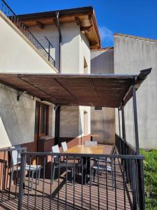 un patio con mesa y sillas bajo un techo en Casa Julio, bonita casa reformada con terraza y jardin privado, en Riezu