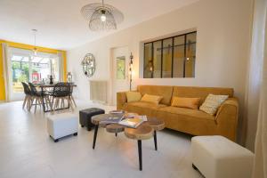 uma sala de estar com um sofá e uma mesa em Chez Odette - SPA, Barbecue, Parking em Albi
