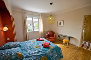 a bedroom with a bed and a chair and a window at Chez Odette - SPA, Barbecue, Parking in Albi