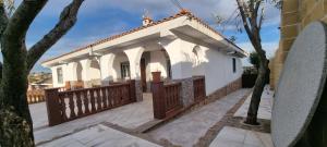 una pequeña casa blanca con una valla de madera en Villa los Cantos, en Toledo