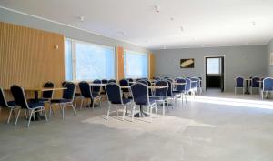 uma sala de conferências com mesas, cadeiras e janelas em Kassikäpa villa em Haapsalu