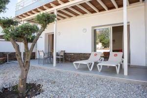 a patio with two white chairs and a table at Résidence du Lido in Argelès-sur-Mer