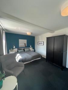 een slaapkamer met een bed en een stoel erin bij Hotel Vin & Gastro in Aabenraa