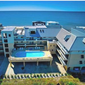 a house with a swimming pool next to the ocean at Beach Paradise - Perfect Ocean Views - Pool in Mexico Beach