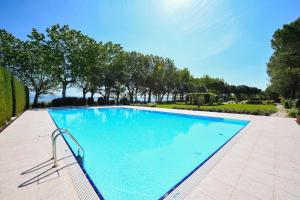 uma grande piscina azul com árvores ao fundo em Acquarius Resort Sirmione - MGH em Sirmione