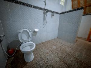 a bathroom with a toilet and a shower at Mertha Sari Resto & Bungalow in Klungkung